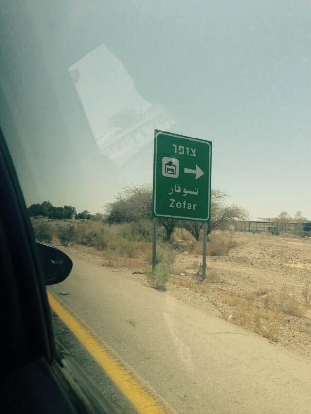 Hitchiking in Israel, passing a sign in Hebrew